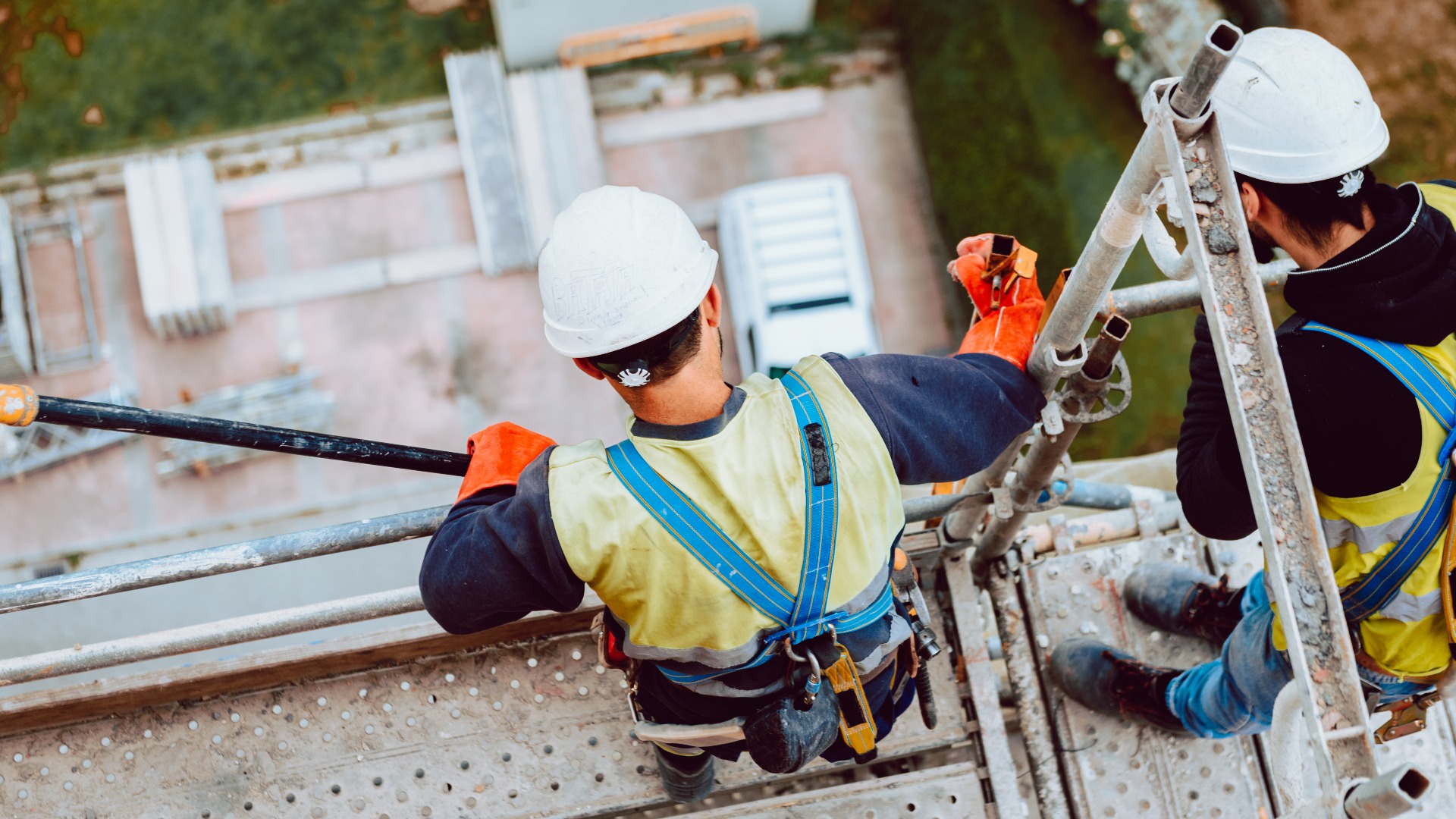 Arbeiter entfernen ein Gerüst in großer Höhe in Oviedo, Asturien, Spanien.