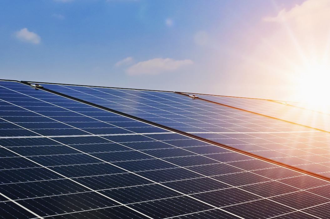 Solarzellen vor dem Hintergrund eines Sonnenuntergangs und eines blauen Himmels. Saubere Energie.