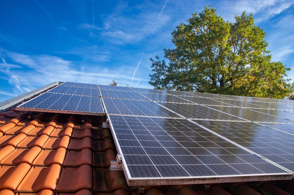 Nasse Photovoltaikmodule vor einem blauen, bewölkten Herbsthimmel